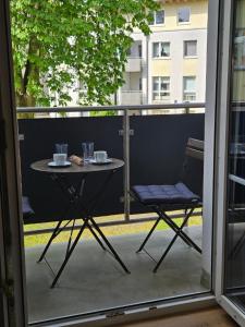 a table and chairs on a balcony with a window at Stilvolle Wohnung mit Balkon & Parkplatz in Moers - Ideal für Business, Familien und Monteure nahe Düsseldorf in Moers