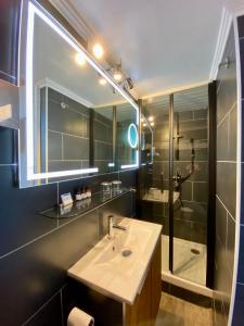 a bathroom with a sink and a mirror and a shower at Hôtel Le Caillebotis in Cap-Ferret +49 photos