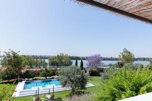 a garden with a swimming pool and a lake at Casas de Juromenha in Juromenha