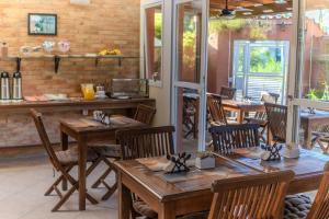 a restaurant with wooden tables and chairs and a brick wall at Pousada Etoile in Juquei