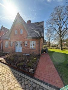 a brick house with a gambrel roof at Dat Südstrandhuus- Ferienwohnung Silke in Wyk auf Föhr