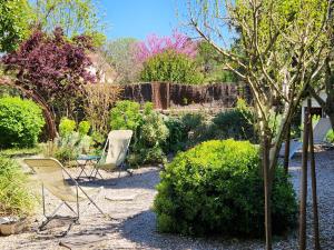 two chairs and a table in a garden at Chez Nous dans notre petit jardin in Montpellier +20 photos