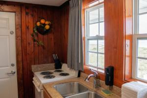 a kitchen with a stove and a sink at Sea Horse Inn and Cottages in Nags Head