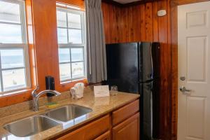 a kitchen with a refrigerator and a sink at Sea Horse Inn and Cottages in Nags Head +66 photos