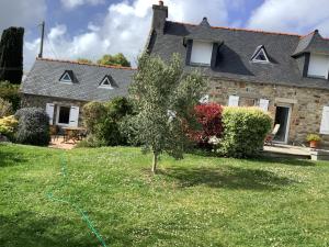a house with a garden and a tree in the yard at Penty in Crozon