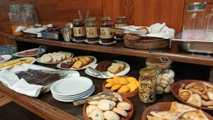 a buffet filled with different types of bread and pastries at Plaza Paradiso by Camberland in Chacras de Coria