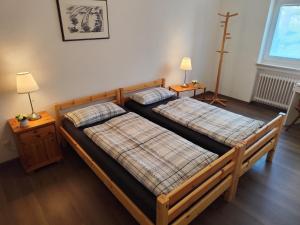 two beds in a room with two lamps on tables at Ferienwohnung Am Alten Brunnen in Gaienhofen