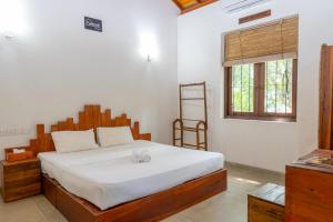 a bedroom with a large bed with a wooden headboard at Battaramulla Boutique Villa in Sri Jayewardenepura Kotte +104 photos