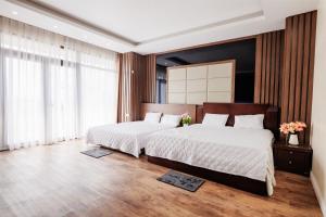 a bedroom with two beds and a large window at BEN Villa in Cẩm Phả Mines