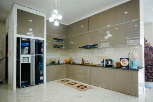 a kitchen with brown cabinets and a refrigerator at BEN Villa in Cẩm Phả Mines