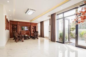 a living room with a large window and a piano at BEN Villa in Cẩm Phả Mines