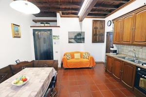 a kitchen with an orange couch in the background at Casa Olaf in Cannobio +9 photos