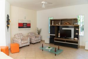a living room with a couch and a tv at Pousada Etoile in Juquei