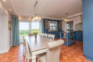 a dining room and kitchen with a table and chairs at Grianán in Ballyconneely