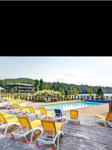 a group of chairs sitting next to a swimming pool at 3306 Studio, Condo sur le Lac in Lac-Superieur
