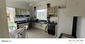 a kitchen with a sink and a stove and a refrigerator at Aconchegante in São Mateus