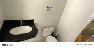 a bathroom with a sink and a toilet at Aconchegante in São Mateus +4 photos