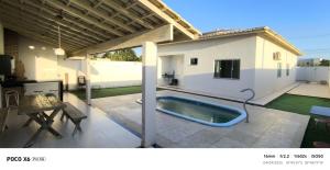 a swimming pool on a patio with a house at Aconchegante in São Mateus
