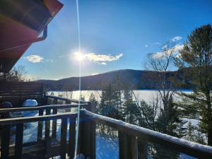 a view from the deck of a house in the snow at 3306 Studio, Condo sur le Lac in Lac-Superieur