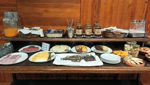 a table with many plates of food on it at Plaza Paradiso by Camberland in Chacras de Coria