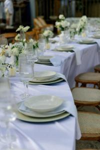 a table with white plates and wine glasses on it at Kuarasy Pousada de Charme Japaratinga in Japaratinga