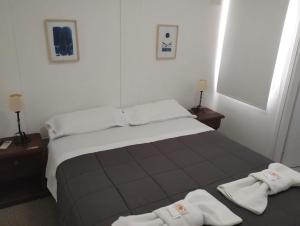 a bedroom with a large bed with towels on it at La Posada de los Robles in Las Grutas