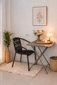 a dining room table with a chair and flowers on it at blissful well treat in Ban Madua Wan