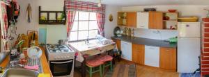 a small kitchen with a stove and a sink at Casa Coasta Tare in Trăisteni +12 photos