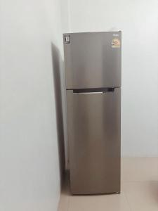 a stainless steel refrigerator in a corner of a room at blissful well treat in Ban Madua Wan