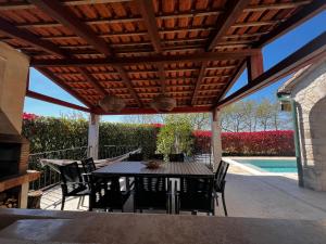 a patio with a table and chairs and a pool at Villa Dracena mit privatem Saltwater Pool in Višnjan