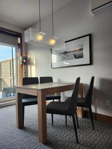 a dining room with a wooden table and chairs at 3306 Studio, Condo sur le Lac in Lac-Superieur