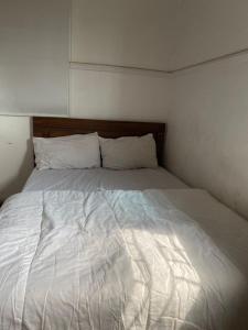 a large white bed in a small room at Beulah House Lounge in Ibadan +7 photos