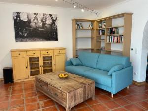a living room with a blue couch and a coffee table at See & Natur Apartment Uffing in Uffing