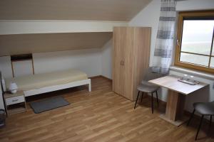 a small room with a bed and a table and a window at Monteurzimmer, Gästezimmer, Ferienwohnung in Altötting