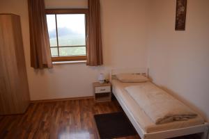 a small bedroom with a bed and a window at Monteurzimmer, Gästezimmer, Ferienwohnung in Altötting +1 photo