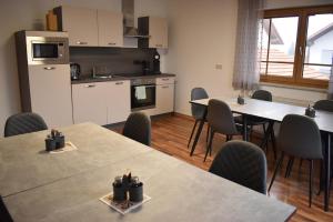a room with tables and chairs and a kitchen at Monteurzimmer, Gästezimmer, Ferienwohnung in Altötting