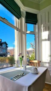 a table in a room with a large window at Craigbuie Guesthouse in Killin