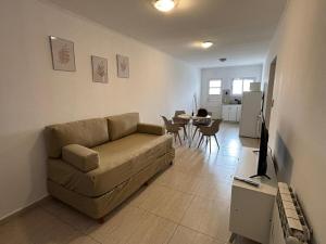 a living room with a couch and a tv in it at La Pampa Apartment in General Roca