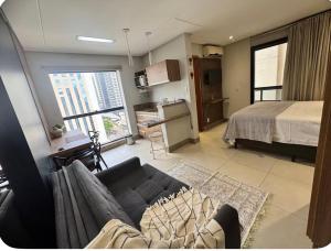 a living room with a couch and a bed at Sun Square Suítes By Temporada Gyn in Goiânia