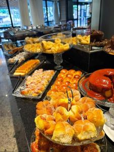a buffet filled with lots of different types of food at Sun Square Suítes By Temporada Gyn in Goiânia +8 photos