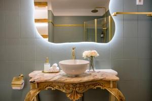 a bathroom with a bowl sink on a table with a mirror at Casa Rosa Sé - Luxury Boutique Guest House in Faro +35 photos