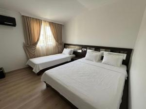 a hotel room with two beds and a window at Emilia Hotel Batumi Old Town in Batumi