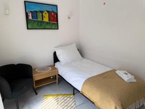 a small bedroom with a bed and a chair at Homestay in Dąbrowa Górnicza