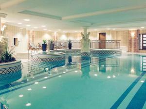 a woman is standing in a swimming pool at Mercure Dartford Brands Hatch Hotel & Spa in Dartford
