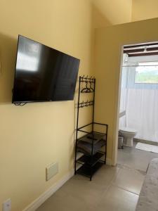 a flat screen tv on the wall of a room at Suíte confortável no centro da cidade in Miguel Pereira
