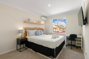 a bedroom with a bed and a desk and a window at Elysian Fields in Joondalup in Perth