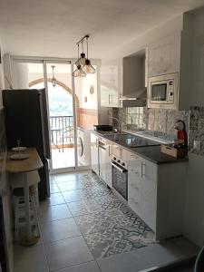 a kitchen with white cabinets and a table in it at Apartamento en Torrox in Torrox