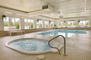a large pool with a hot tub in a building at Super 8 by Wyndham Fort Frances in Fort Frances