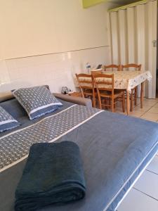 a room with two beds and a dining room with a table at Maisonnette "Les Volets Bleus" in Orgedeuil