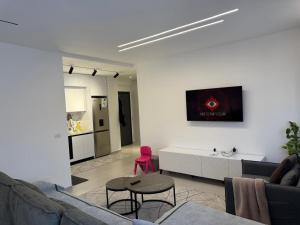 a living room with a couch and a table at Mel Apt in Golem +4 photos